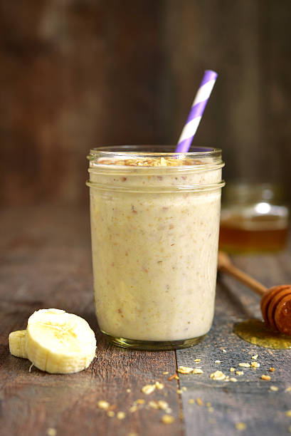 Banana smoothie with oat. Banana smoothie with oat in a jar on rustic wooden background. blended drink photos stock pictures, royalty-free photos & images
