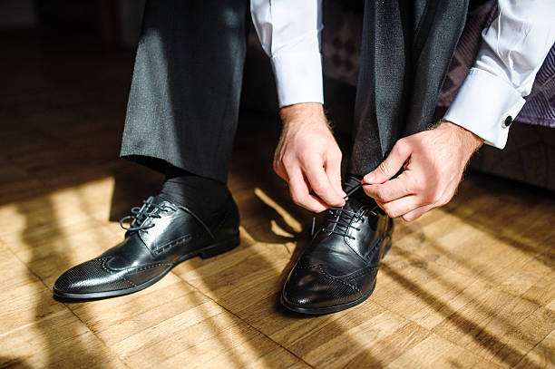 istock Business man tying shoe laces on the floor 516075314