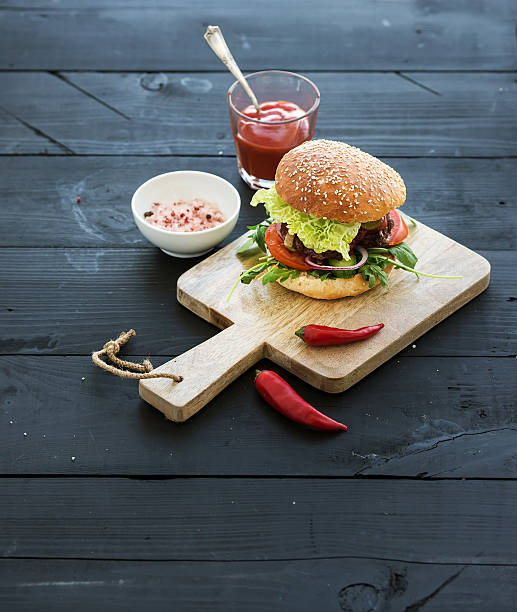 istock Fresh homemade burger on dark serving board with spicy tomato 516076376
