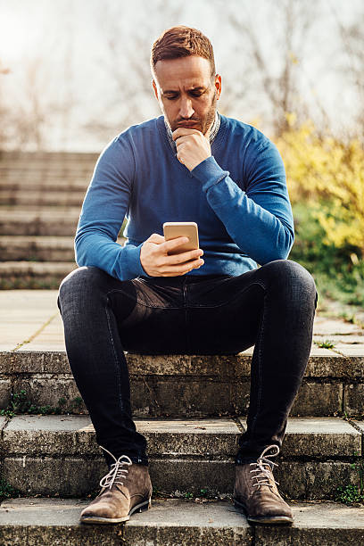 istock Young casual handsome man using phone outdoors and smiling 516077070