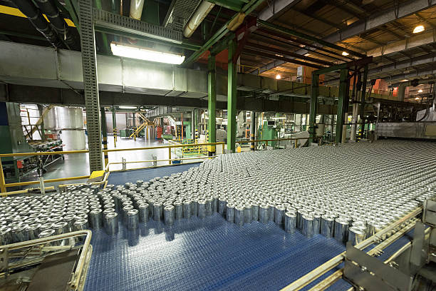 Aluminium cans being made in an industrial factory Metal drinks cans on production line in manufacturing plant. Industrial building interior with abundance of aluminium cans. aluminum plant stock pictures, royalty-free photos & images