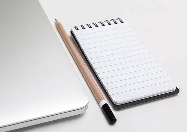 Photo of Laptop, notepad and pencil, The Blogger instrument