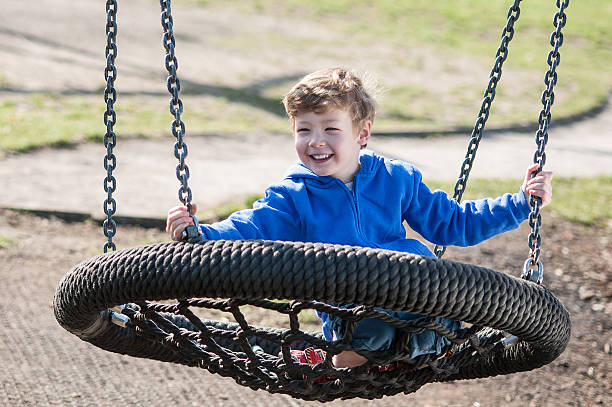 istock Happy Boy Swinging on a Big Round Swing 516079857