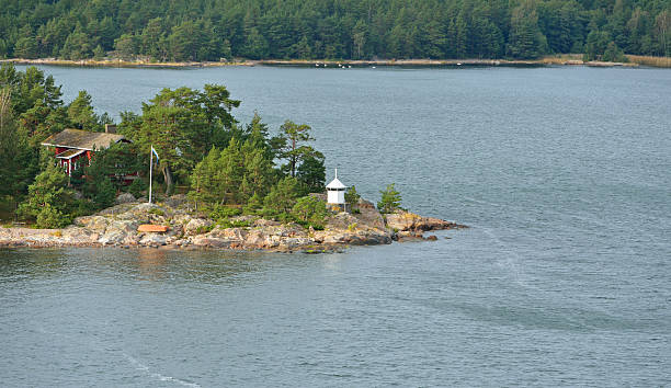 istock Green Island with red house and lighthouse 516081061