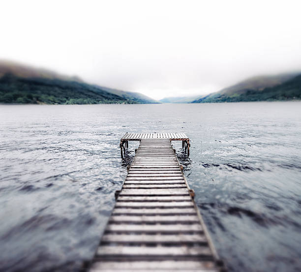 A tilt-shifted view along a traditional wooden pier, out to Loch Earn in Scotland's Highlands.