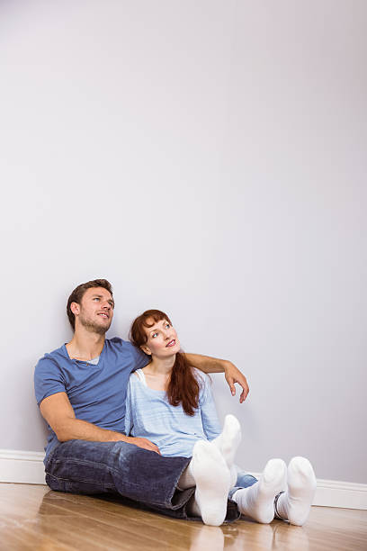 istock Couple sitting on floor together 516081599