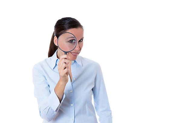 istock smiling young woman with magnifying glass 516083611
