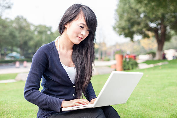 istock young asian woman with laptop 516084095