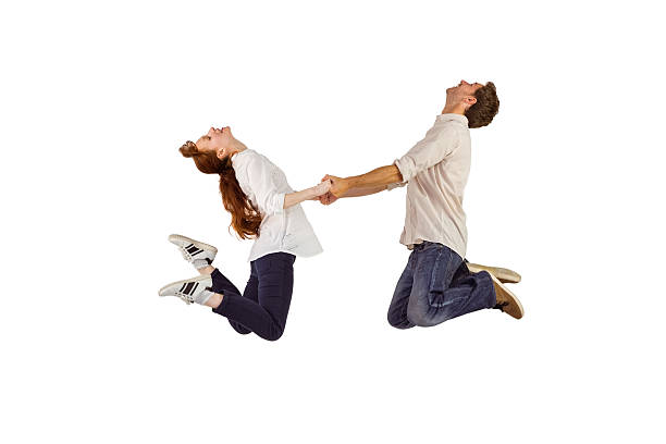 istock Couple jumping and holding hands 516084191