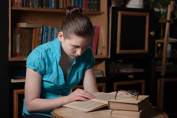 istock young girl in glasses reading a book 516098948