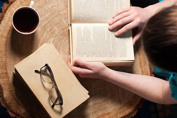 istock girl with a Cup of tea and book on table 516100846