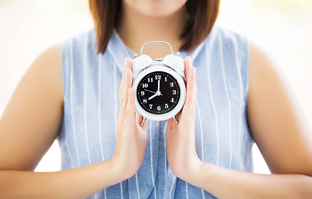 istock asian beautiful girl holding classic alarm clock 516103768