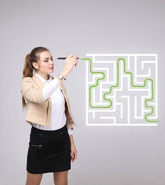 istock Young woman finding the maze solution, writing on whiteboard 516104860