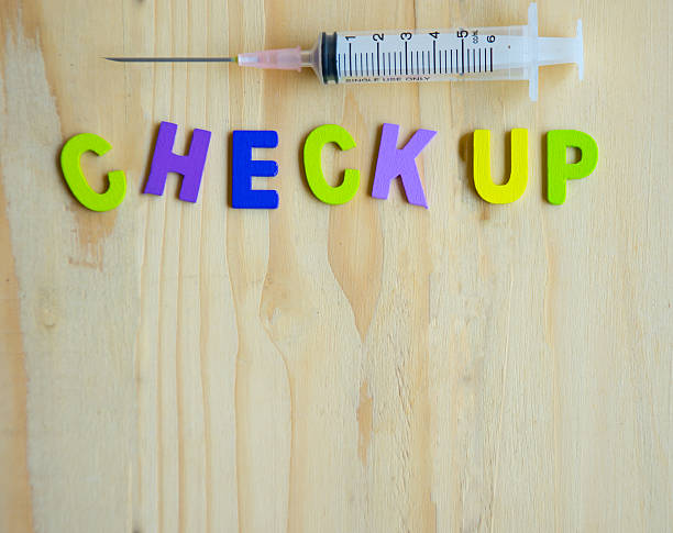 istock Health check up text with syringe on wood table 516105686
