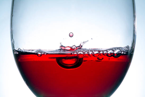 red wine in glass, splashing, splash, bubbles, wave of red wine close up