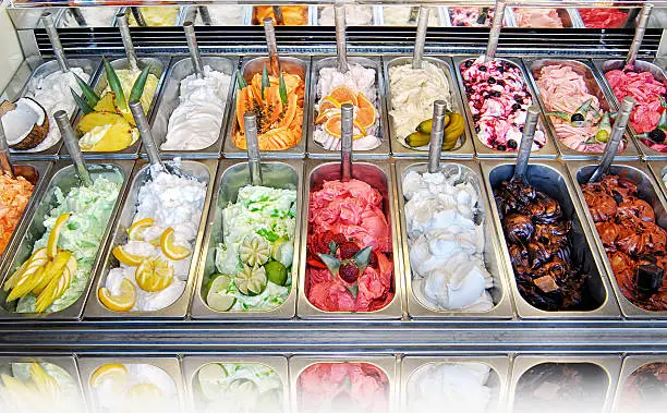 Display of assorted ice creams in metal tubs in a shop or ice cream parlour