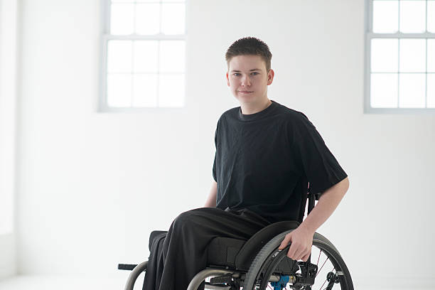 discapacitados adolescente sentado en una silla de ruedas - t shirt child white portrait fotografías e imágenes de stock
