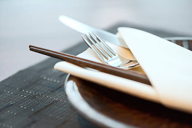 Classy place setting for trendy Asian-Western fusion cuisine - chopsticks, fork, and knife in a folded napkin.  Hong Kong, China.