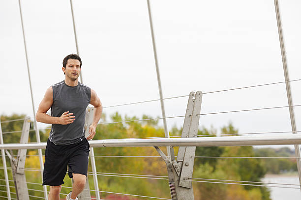 istock Man jogging on the bridge in the city 516113527