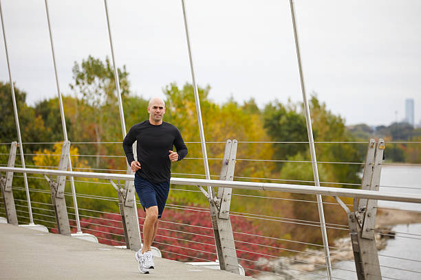 istock Man jogging on the bridge in autumn city 516113897