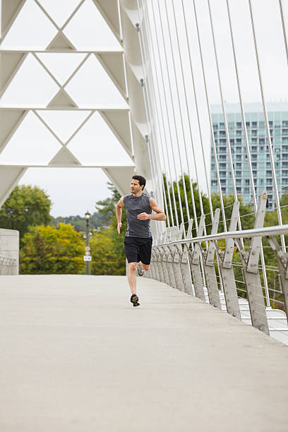 istock Man jogging on the bridge in the city 516113903