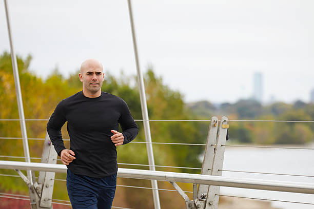 istock Man jogging on the bridge in autumn city 516113907