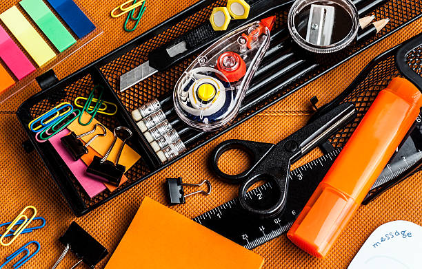 colorful school and office supplies colorful school and office supplies on an orange background paper clip binder clip box paper stock pictures, royalty-free photos & images