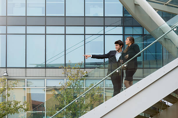 istock Young business couple smiling with modern buildind background 516115621