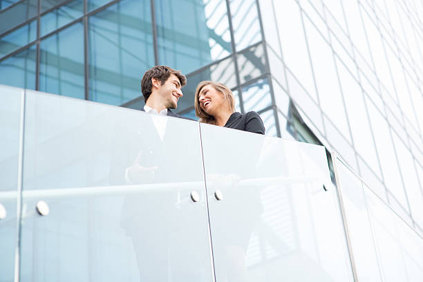 istock Young business couple smiling with modern buildind background 516115711