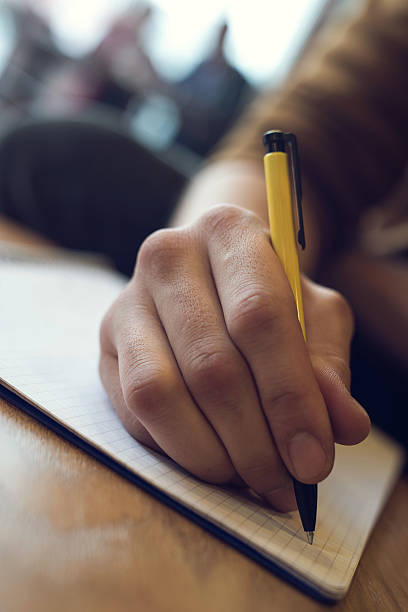 istock Close up of unrecognizable person writing in a notebook. 516132320