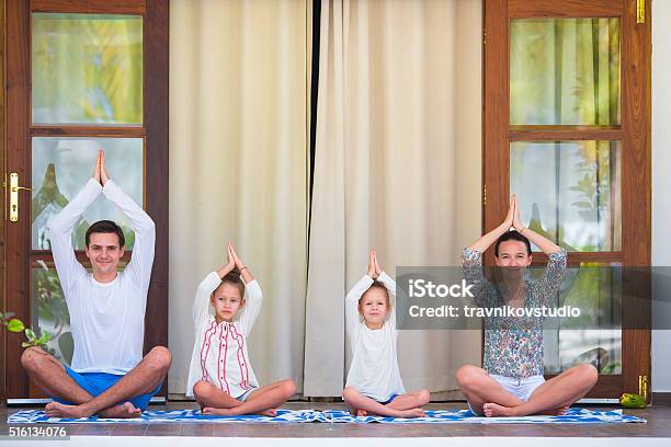 Happy Young Family Meditating On The Terrace Stock Photo - Download Image Now - Adult, Balance, Child