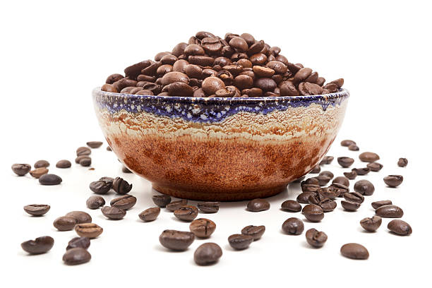 Bowl of coffee beans on white background