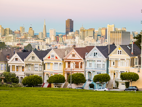The Painted Ladies of San Francisco during twilight. The city skyline can be seen in the background.