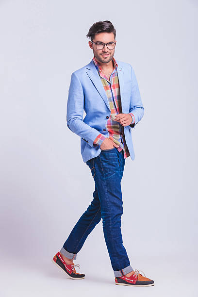 istock young man wearing glasses walking in studio 516138820