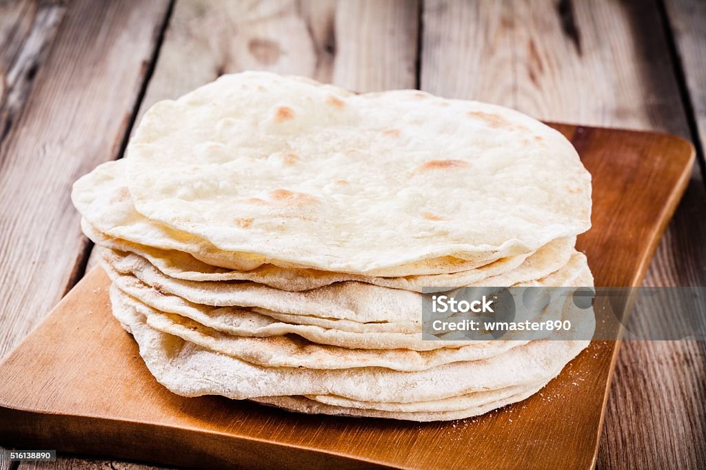 Stack of homemade wheat tortillas Stack of homemade wheat tortillas on wooden table Bread Stock Photo