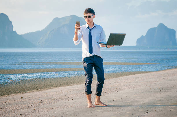 istock Business man working with laptop and smartphone beach background 516141854