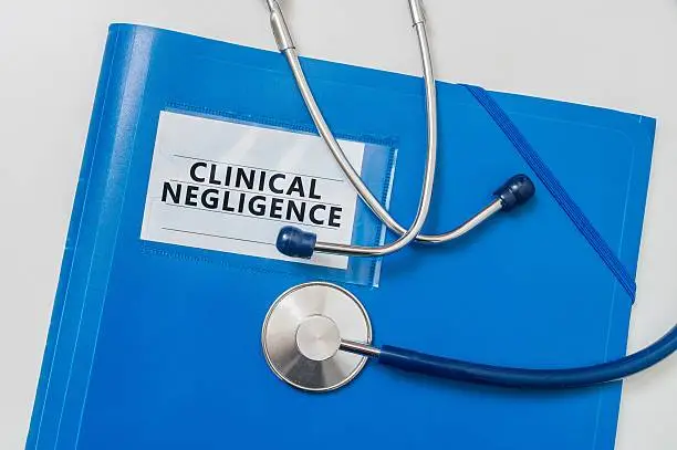 Photo of Blue folder with Clinical Negligence. Medical failure concept.