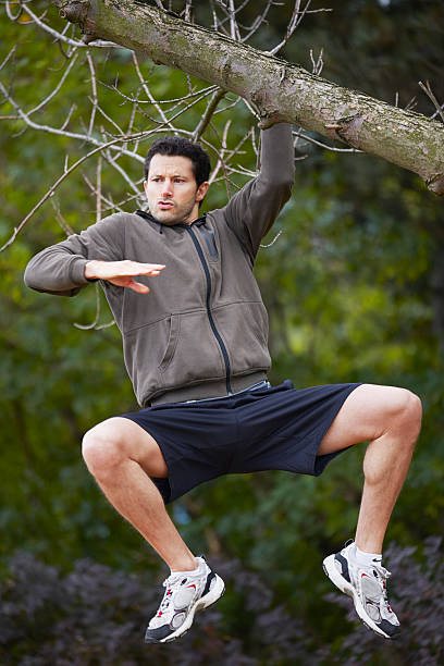 homme accroché à un arbre dans le parc de la drôle de tête - sportsman tree people recreational pursuit photos et images de collection