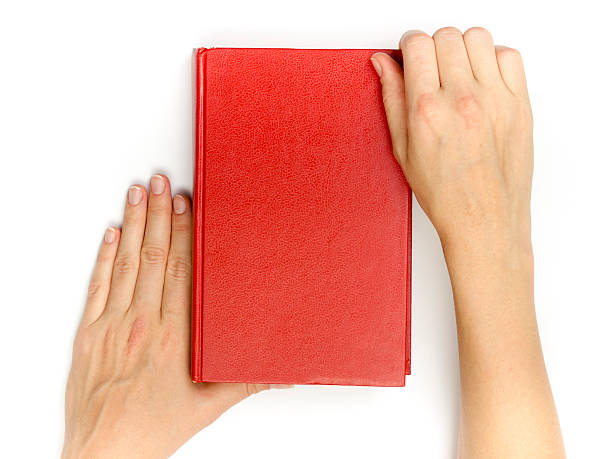 istock Hands hold blank red hardcover book on white background 516144756