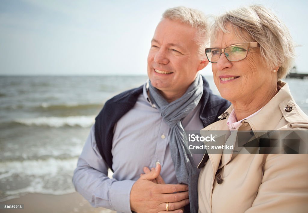 Senior couple by the sea. Cheerful senior couple walking and enjoying sun near Baltic sea. Denmark, Copenhagen. 60-69 Years Stock Photo