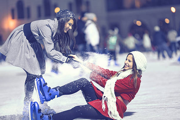 two girls ice skating stock photo