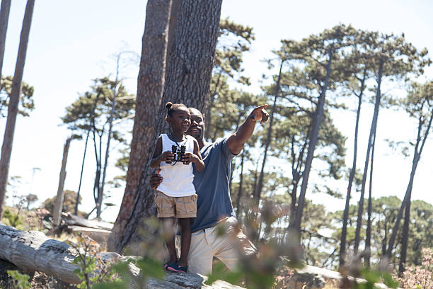 istock African father holding his daughter on the log 516163955