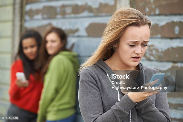Teenage Girl Being Bullied By Text Message Stock Photo - Download Image Now - People, Text Messaging, Bullying