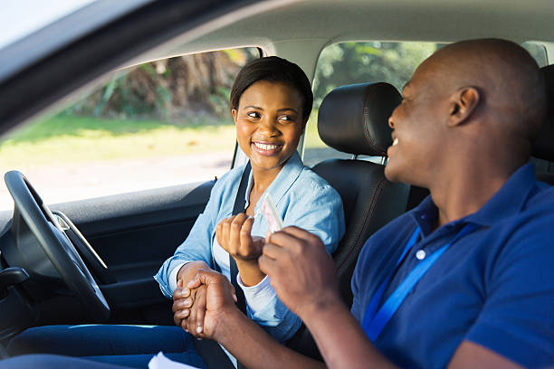 istock black woman being handed driver’s license by driving instructor 516165539