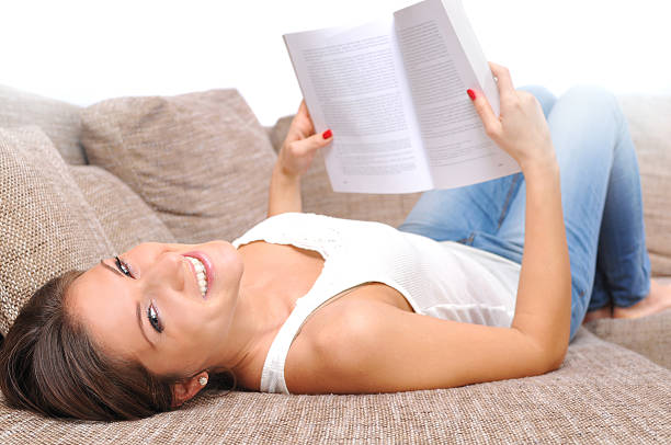istock Beautiful caucasian girl relaxing, lying on bed and reading book 516166517