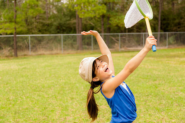 istock Elementary girl enjoys discovering nature. Butterfly net outdoors. 516166639