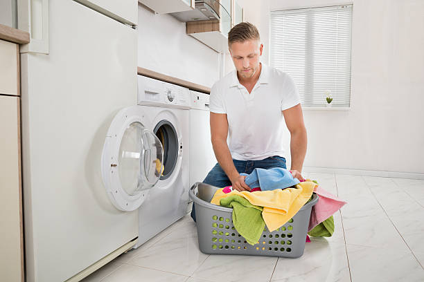 istock Man Putting Colorful Towels Into The Washing Machine 516174310
