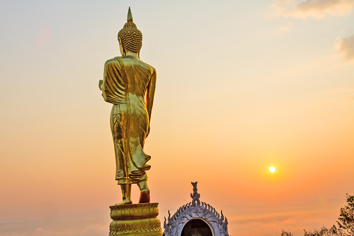 Golden sculpture Buddha idyllic with sunrise at country of Nan, Thailand