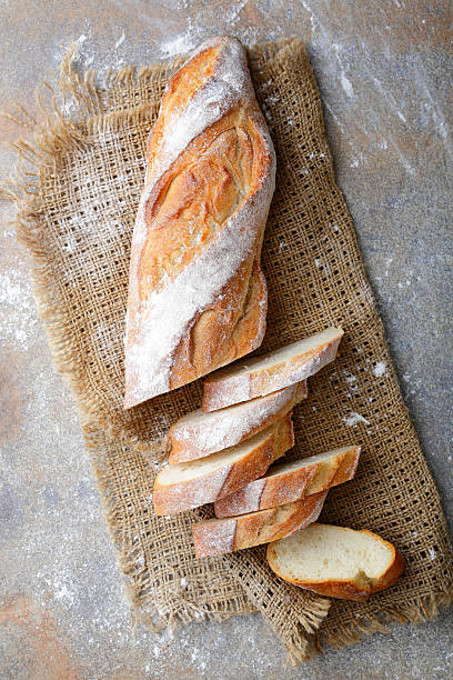 Sliced Baguette on the sackcloth Sliced Baguette on the sackcloth on slate baguette stock pictures, royalty-free photos & images