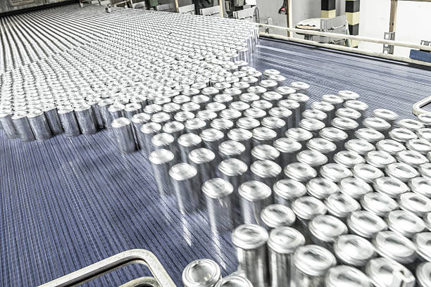 Aluminium cans moving along conveyor belt in processing plant